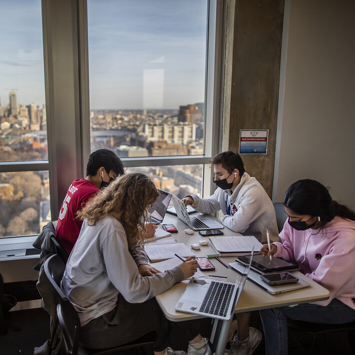 students study at a rooftop lounge overlooking the Philadelphia skyline
